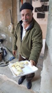 Khalid offering some Palestine pastries at Zuluf—The Olive Wood Factory!